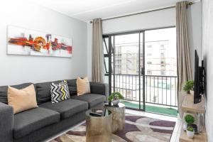 a living room with a couch and a large window at Alimama Spaces: The Robert's Greenlee Apartment in Sandown