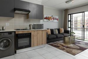 a kitchen with a stove and a couch in a room at Alimama Spaces: The Robert's Greenlee Apartment in Sandown