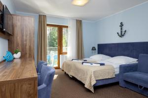 a bedroom with a bed and two blue chairs at VivaLaMer in Pobierowo