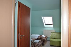 um quarto com uma cama, uma cadeira e uma porta em Holdfényszállás em Szeged