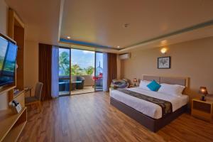 a hotel room with a bed and a television at Season Paradise in Thulusdhoo