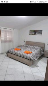 1 dormitorio con 1 cama con almohadas de color naranja en Appartamento Ariosto, en Bosa