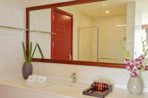 a bathroom with a sink and a large mirror at Season Paradise in Thulusdhoo