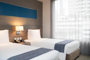 曼谷的住宿－曼谷沙通智选假日酒店，酒店客房设有两张床和窗户。