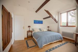 a white bedroom with a bed and a window at Ferme des Vallees in Soindres