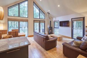 un ampio soggiorno con mobili in pelle e finestre di Host & Stay - Simon Howe Lodge a Whitby