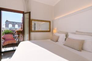 a white bedroom with a large bed and a window at Hotel Giulietta e Romeo ***S in Verona