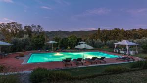 una piscina con sillas y sombrillas en VILLALTA 18&2, Emma Villas, en Arezzo