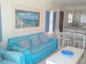 a living room with a couch and a table at Little Greece - Beach House Apartment by Mykonos in Langebaan