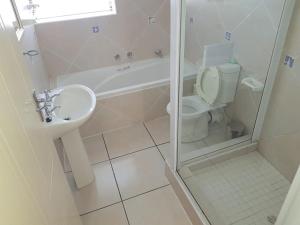 La salle de bains est pourvue de toilettes, d'un lavabo et d'une douche. dans l'établissement Little Greece - Beach House Apartment by Mykonos, à Langebaan