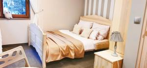 a small bedroom with a bed and a crib at Willa Sowia Dolina in Karpacz
