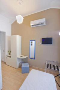 um quarto com uma mesa e um frigorífico branco em B&B Antonello da Messina em Messina