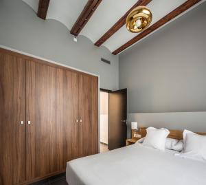 a bedroom with a large bed and a wooden cabinet at Mon Suites San Nicolas in Valencia