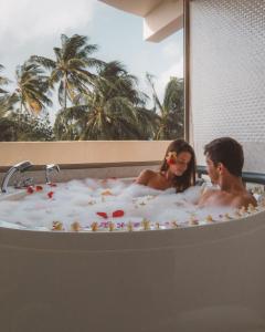 a man and woman sitting in a bath tub at Season Paradise in Thulusdhoo