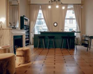 una sala de estar con un bar verde con taburetes en ADA, en Amberes