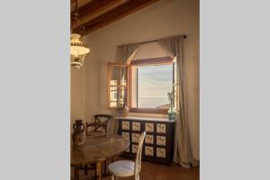 jadalnia ze stołem i oknem w obiekcie Casa Mistral, Un paraíso de Mar y Montaña w mieście Valldemossa