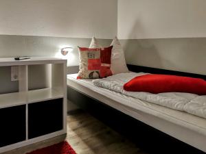 a small bedroom with a bed with a red blanket at Hahnenklee Ferienpark 409 & 211 in Goslar
