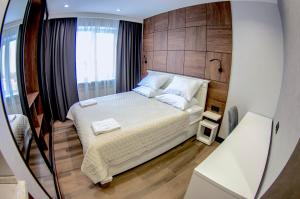 a small bedroom with a bed with a wooden headboard at Hotel Invite in Vladimir