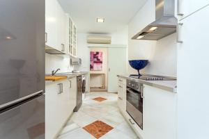 - une cuisine avec des placards blancs et un bol bleu sur le comptoir dans l'établissement Genteel Home Abades, à Séville