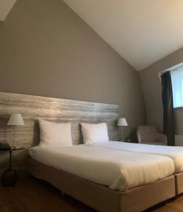 Postel nebo postele na pokoji v ubytování Hotel Au Quartier