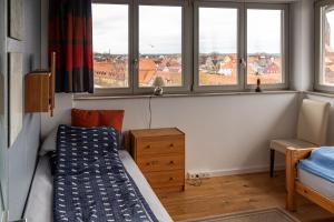 ein kleines Schlafzimmer mit einem Bett und Fenstern in der Unterkunft Ferienwohnung Kiek ut in Barth