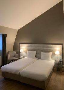 Postel nebo postele na pokoji v ubytování Hotel Au Quartier