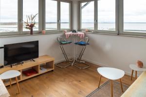 ein Wohnzimmer mit einem Flachbild-TV und Stühlen in der Unterkunft Ferienwohnung Kiek ut in Barth