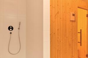 a shower with a shower head in a bathroom at Adler Lodge D2 by AA Holiday Homes in Tauplitz +11 photos