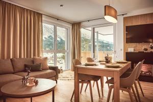 a living room with a table and a couch at Adler Lodge D3 by AA Holiday Homes in Tauplitz