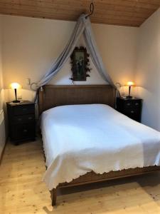 a bedroom with a white bed and two night stands with lamps at Ferienhaus zwischen Wald und See in Möhnesee
