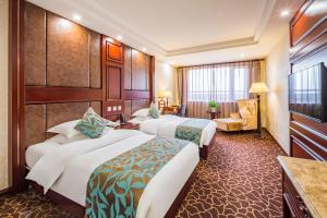 una camera d'albergo con due letti e una sedia di Beijing Commercial Business Hotel a Pechino