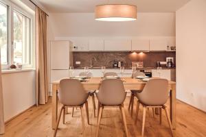 a kitchen and dining room with a wooden table and chairs at die Tauplitz Lodges - Alm Lodge A13 by AA Holiday Homes in Tauplitz