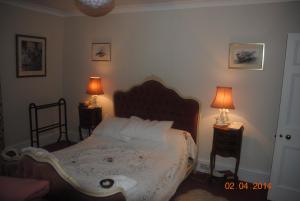 a bedroom with a bed and two lamps on tables at Elmfield in Northlew