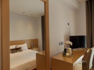 een hotelkamer met een bed en een spiegel bij Hotel Alexandros in Anchialos