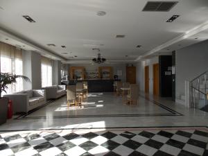 - un salon avec un sol en damier dans l'établissement Hotel Alexandros, à Anchialos