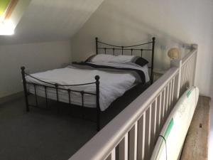 a bedroom with a bed with a white railing at Surf Shack - Impeccable 1-Bed Cottage in Shorwell in Shorwell