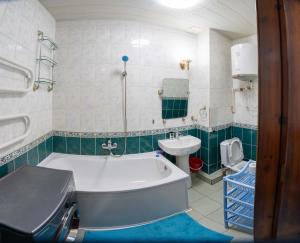 ein Badezimmer mit einer Badewanne, einem WC und einem Waschbecken in der Unterkunft Дом с прекрасным видом г Павлодар in Pawlodar