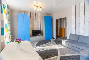 ein Wohnzimmer mit einem Sofa und einem TV in der Unterkunft Дом с прекрасным видом г Павлодар in Pawlodar
