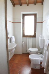 a bathroom with a toilet and a sink and a window at La Locanda Cuccuini in Cavriglia