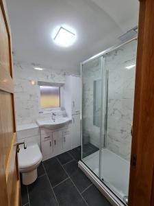 W łazience znajduje się prysznic, toaleta i umywalka. w obiekcie Bruxie Holiday Cottages - Honeysuckle Cottage w mieście Maud