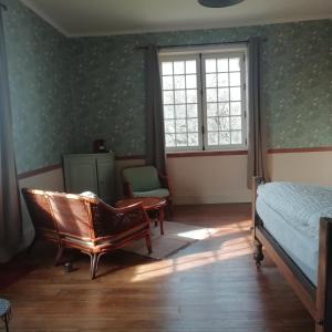 1 dormitorio con 1 cama, 1 silla y 1 ventana en Lieu Baudouin, en Livarot