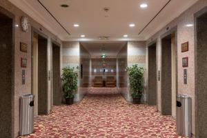 un pasillo de un hotel con plantas en un pasillo en Palestine Hotel Makkah, en La Meca