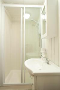 biała łazienka z umywalką i prysznicem w obiekcie Lavender lodge w Newquay