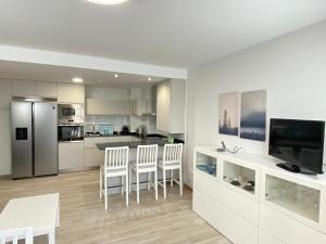 a kitchen with white cabinets and a white table and chairs at Apartamento nuevo, accesible y con piscina !!! in Salamanca