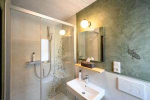 a bathroom with a sink and a shower with a shower at Bavaria Biohotel in Garmisch-Partenkirchen