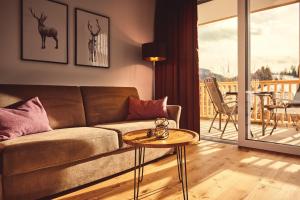 a living room with a couch and a table at die Tauplitz Lodges - Alm Lodge A6 by AA Holiday Homes in Tauplitz