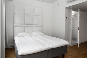 a white bedroom with a bed with white sheets at Omena Hotel Turku Kauppiaskatu in Turku