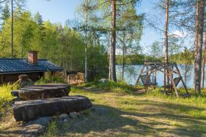 a group of logs sitting in front of a lake at Vuorijärvi cottage in Enonkoski