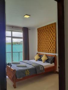 a bedroom with a bed with a large window at Flamingo's Nuwara Eliya in Nuwara Eliya