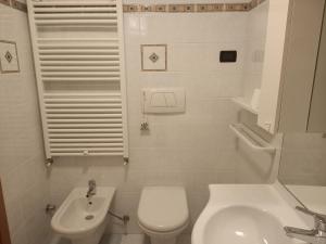 een witte badkamer met een toilet en een wastafel bij Andalo 2000 in Andalo